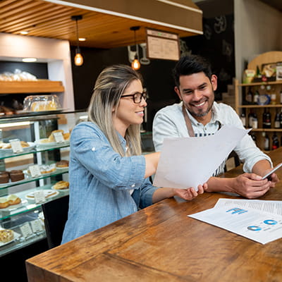 Shot of a man and woman going through paperwork together in their coffee shop